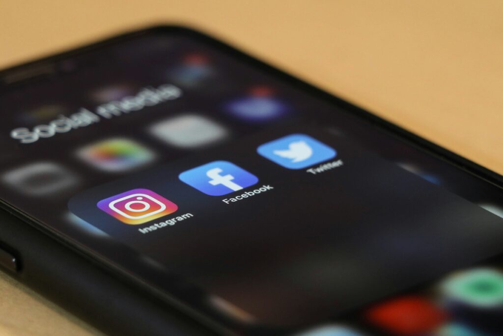 Social media platform icons on the screen of a smartphone.